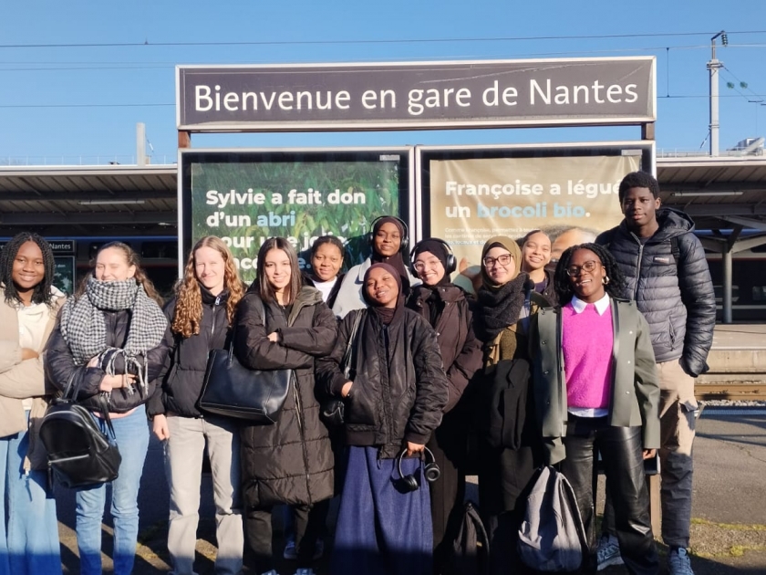 les jeunes devant le panneau Nantes à la gare sncf